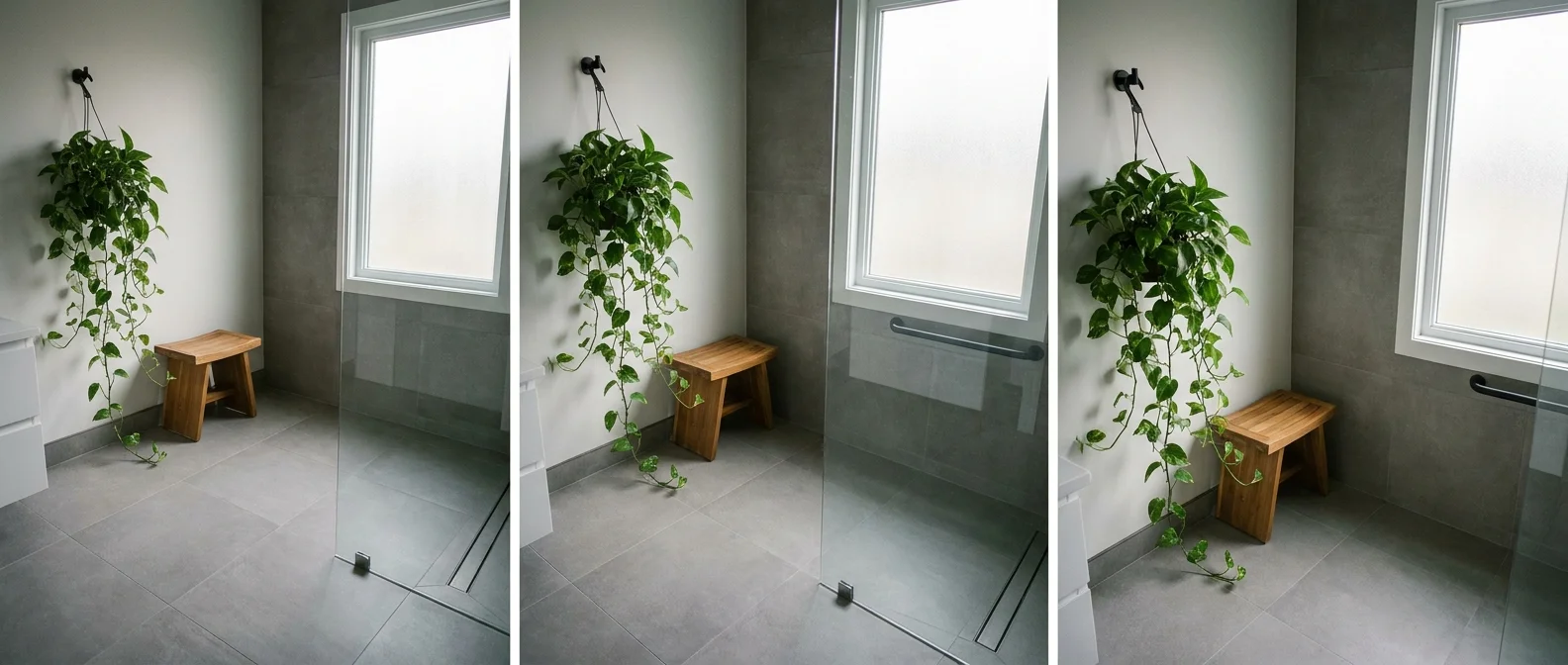 A modern bathroom featuring a curbless walk-in shower with grey tiles and a hanging green plant.