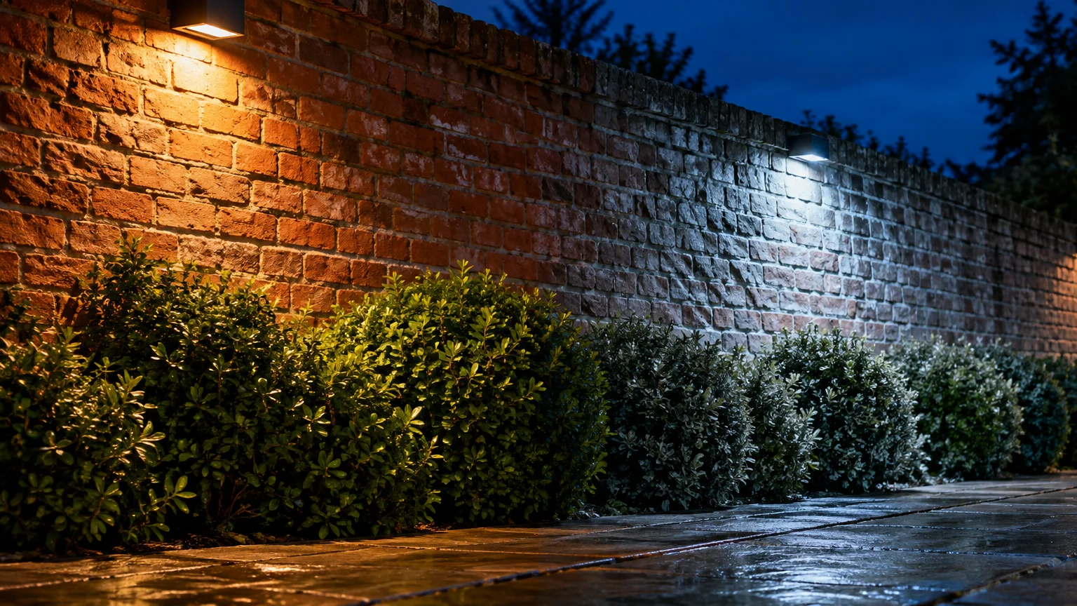 A brick wall and bushes illuminated by warm golden outdoor light on the left and cool blue-white light on the right.